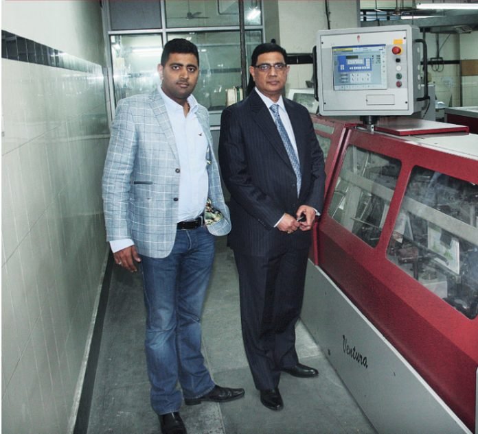 Bhuvnesh Seth, managing director, and his son Vikaran Seth, director of Replika Press with the Muller Martini Ventura sewing machine at the Replika Press plant in Kundli, Haryana. Pho