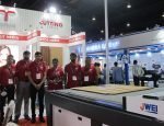 Technova shows its digital cutting table and signage media Technova team standing with Jingwei CB03II-2516 digital cutting table at their Stand in Media Expo. Photo: IPP