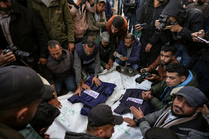 image Journalists and other mourners gather around the bodies of four Palestinian journalists and a media worker killed by an Israeli airstrike in Gaza’s Nuseirat refugee camp on December 26, 2024. (Photo: AP/Abdel Kareem Hana via CPJ)