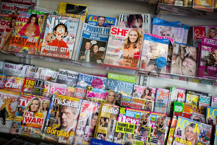 UK Magazines on a Newsstand London, United Kingdom- 14 August 2011 – UK Magazines of different topics on the shelf of a newsstand in a bus station Photo Zozobela iStock
